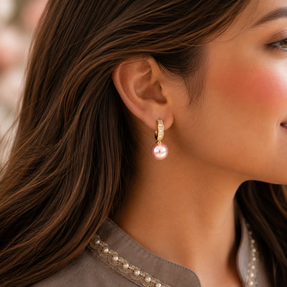 Close-up of a model wearing Blush Pink pearl drop hoop earrings with baguette crystal detailing.