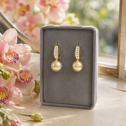Gold crystal hoop earrings with Golden Olive  pearl drops displayed in a premium jewellery stand.