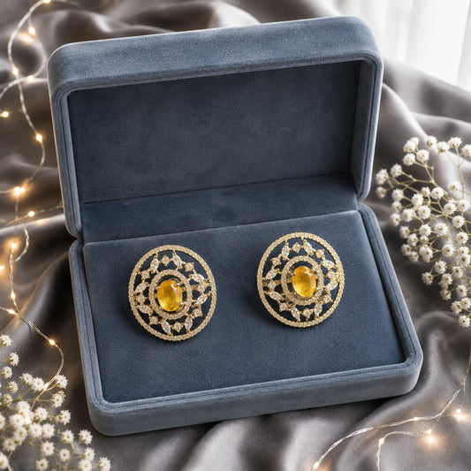 Solstice Studs with golden-yellow oval centre stone, clear zircon detailing and intricate gold-tone openwork.