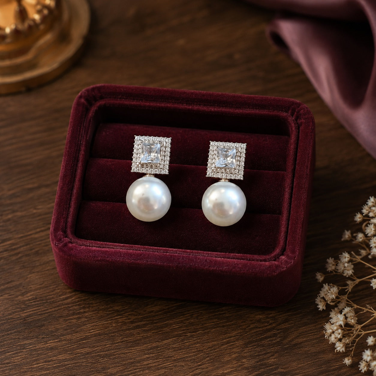 Silver square zircon and white pearl drop earrings displayed in burgundy velvet jewellery box