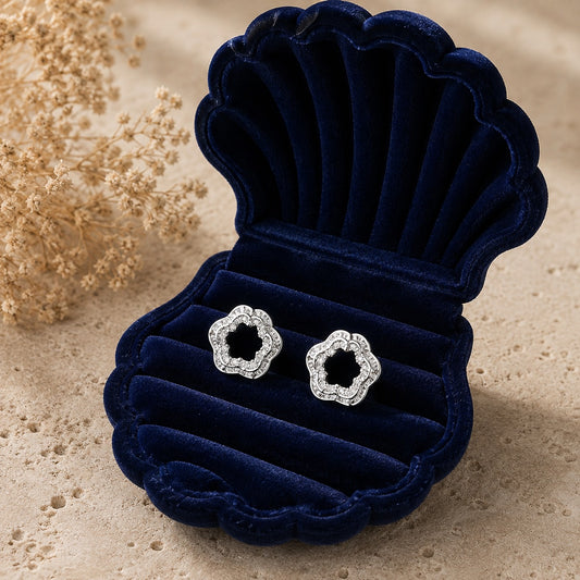 Silver open-centre floral zircon stud earrings displayed in navy velvet jewellery box