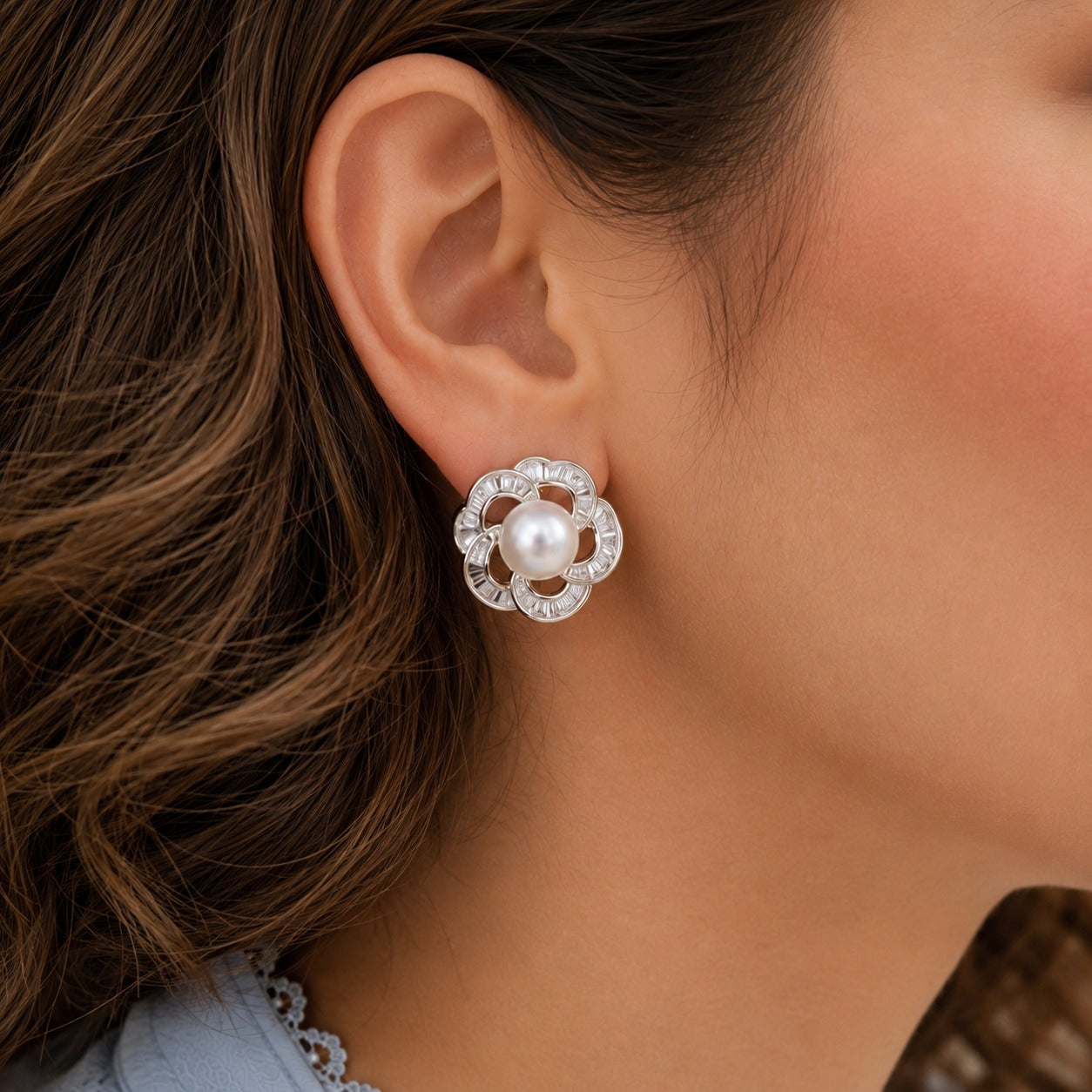 Silver pearl floral stud earring worn on model, close-up view