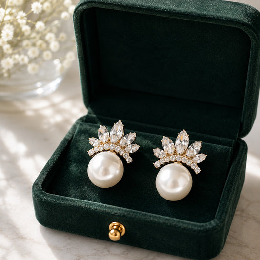 Pearl Crown Stud Earrings in gold displayed in a deep green velvet jewellery box