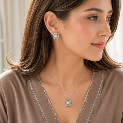 Model wearing matching silver pearl stud earrings and pendant necklace set