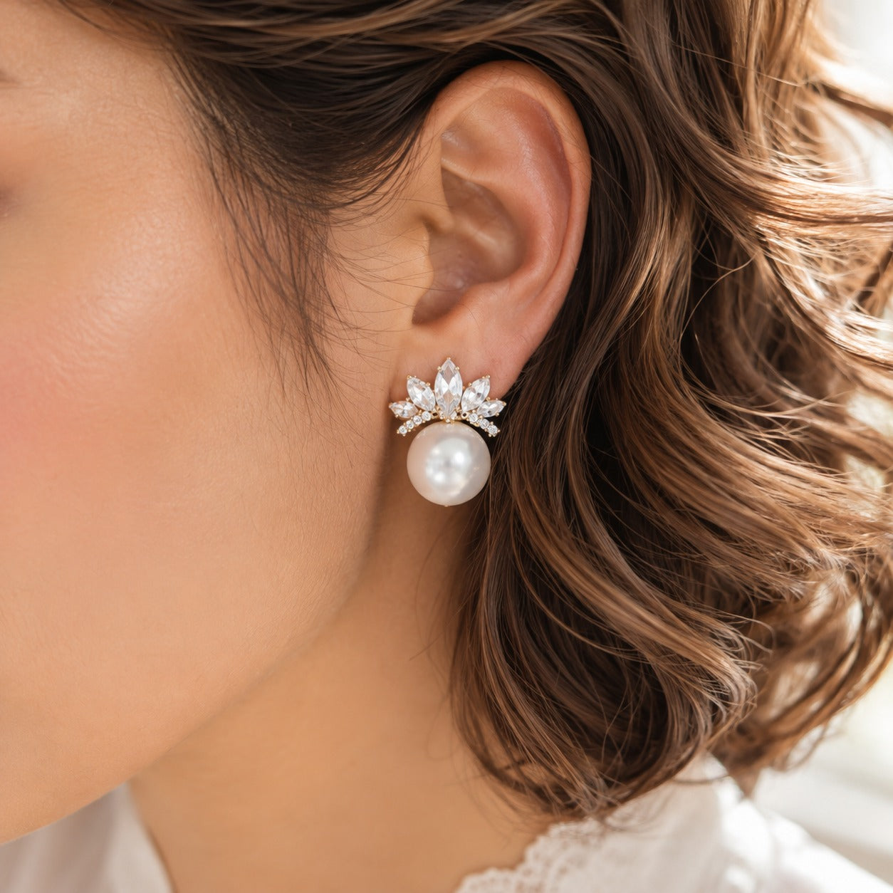 Close-up of model wearing Pearl Crown Stud Earrings with clear crystals and white pearl