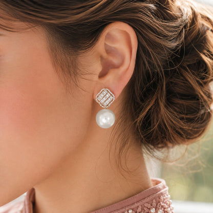 Close-up of model wearing silver-tone Pearl Grid Drop Earrings with geometric crystal top and round pearl