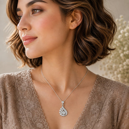 Model wearing silver crystal drop pendant necklace with asymmetric sparkling design