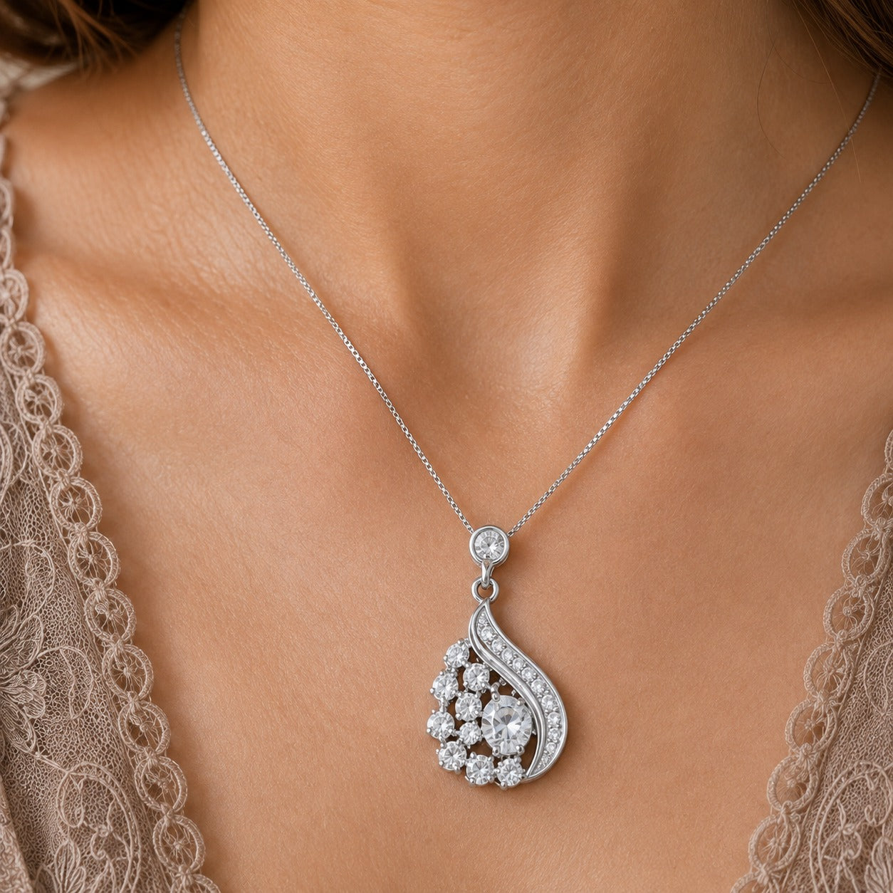 Close up of model wearing silver crystal drop pendant necklace with asymmetric sparkling design
