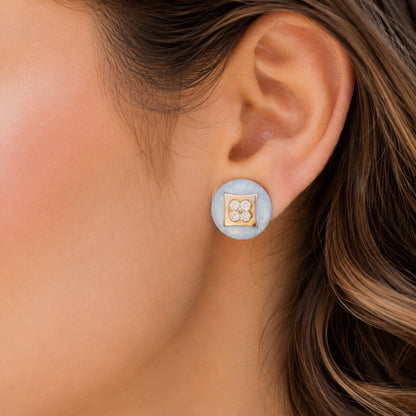 Model wearing Powder Crest Studs featuring powder-blue round bases, gold-tone square centres and four-petal clear zircon detailing.