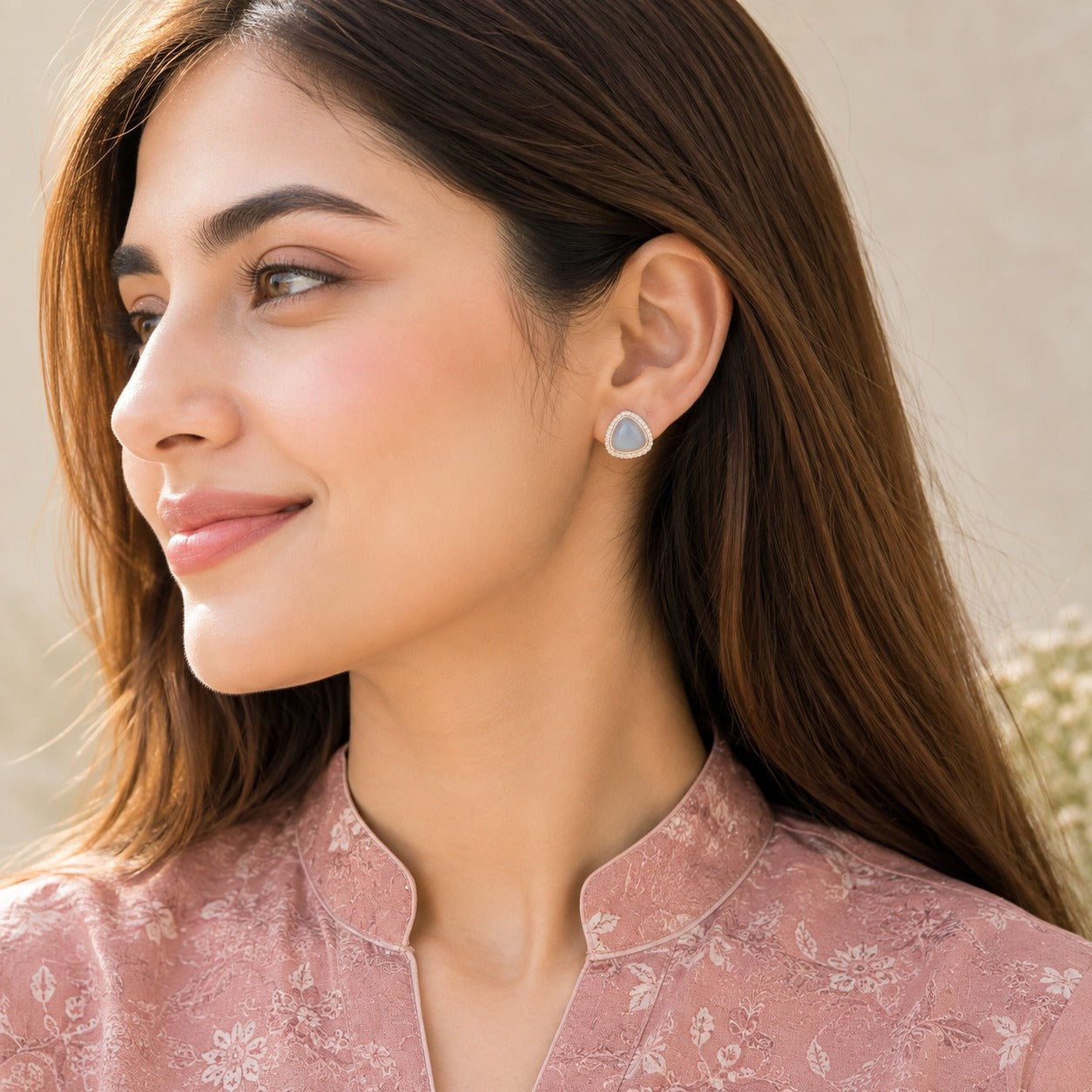 Model wearing Glacier Cove Studs with soft ice-blue triangular centres and sparkling clear zircon borders.