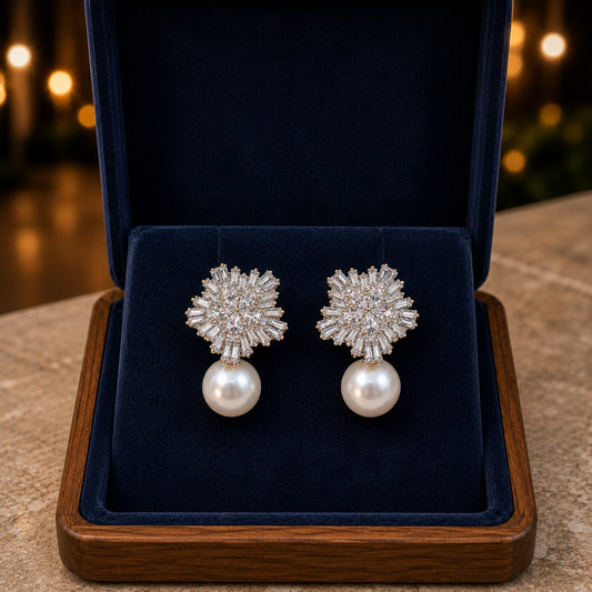 Clear zircon floral statement earrings with baguette-style detailing and round pearl drops displayed in a navy jewellery box.