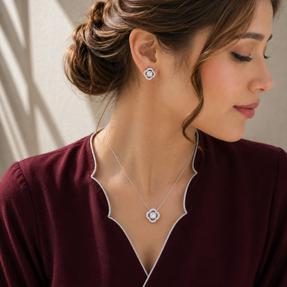 Model wearing the Vela Loop silver-tone clear zircon pendant and matching stud earrings with a deep burgundy outfit.