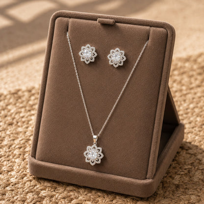 Solenne clear zircon pendant and matching stud earrings displayed on a taupe jewellery stand.