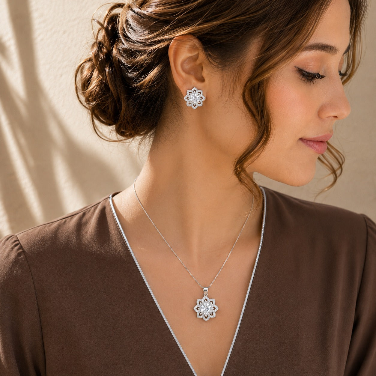 Model wearing Solenne clear zircon pendant necklace and matching silver-tone floral stud earrings.