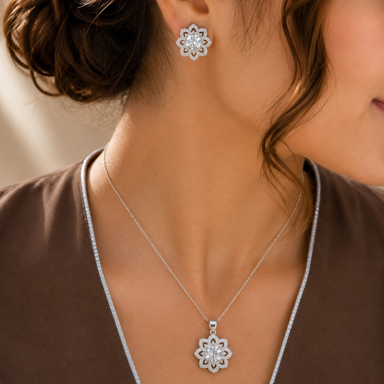  close up of a Model wearing Solenne clear zircon pendant necklace and matching silver-tone floral stud earrings.