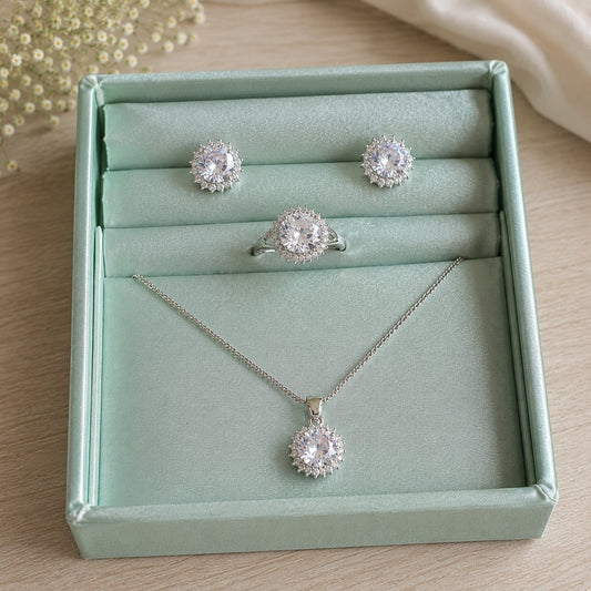 Close-up of coordinated round clear zircon jewellery set featuring earrings, pendant and ring with a radiating stone border.