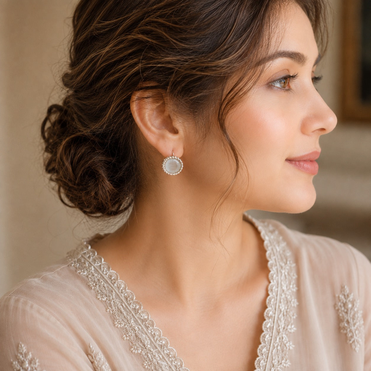 Silver-tone round  hook back earrings with pearlescent white centres and twisted-rope borders worn on the ear by a model