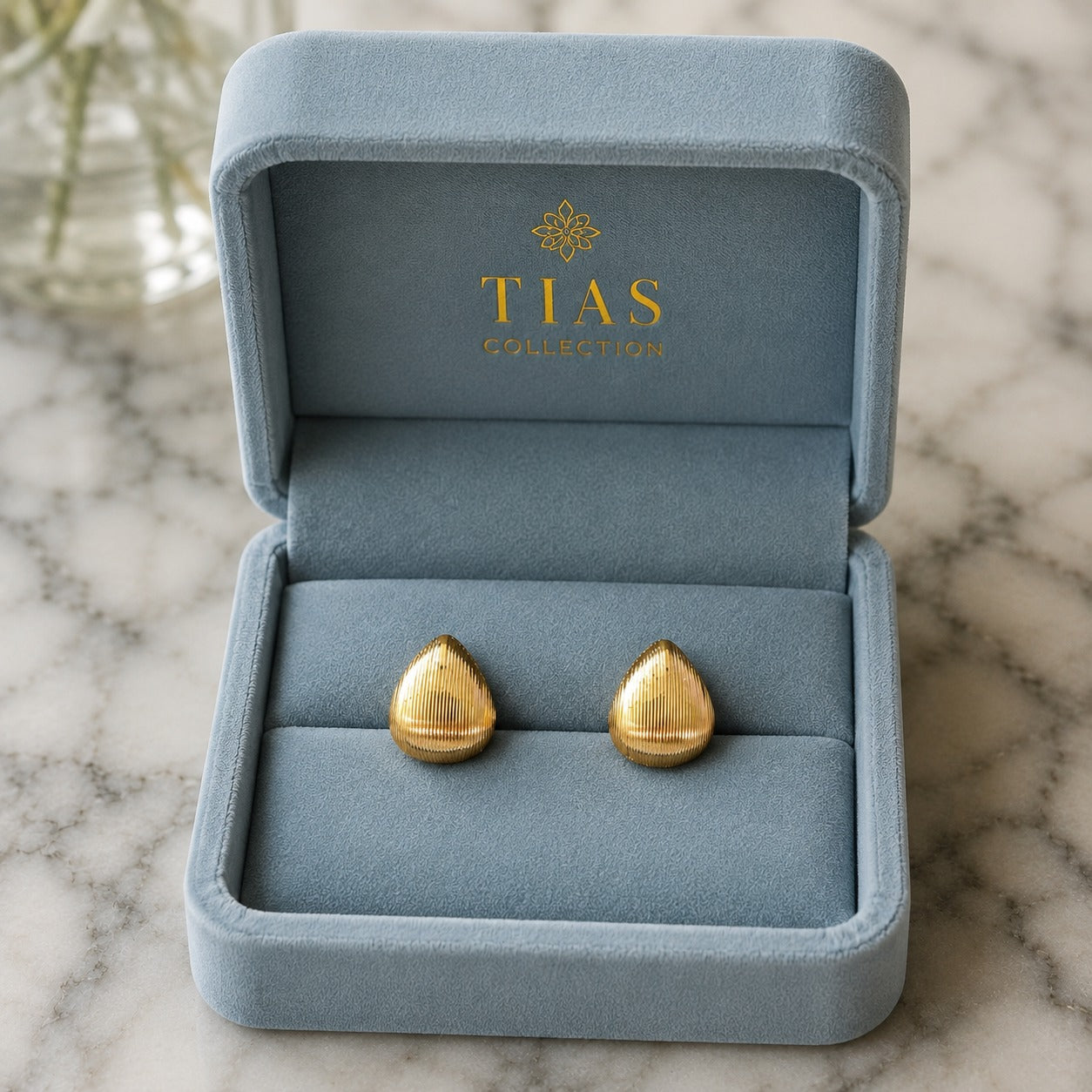 Gold-tone rounded drop earrings with fine vertical ridged texture and a softly domed finish.