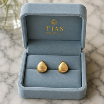Gold-tone rounded drop earrings with fine vertical ridged texture and a softly domed finish.