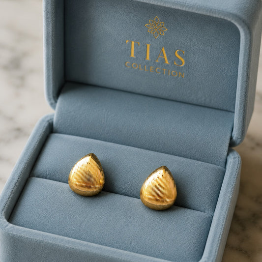 Gold-tone rounded drop earrings with fine vertical ridged texture and a softly domed finish.