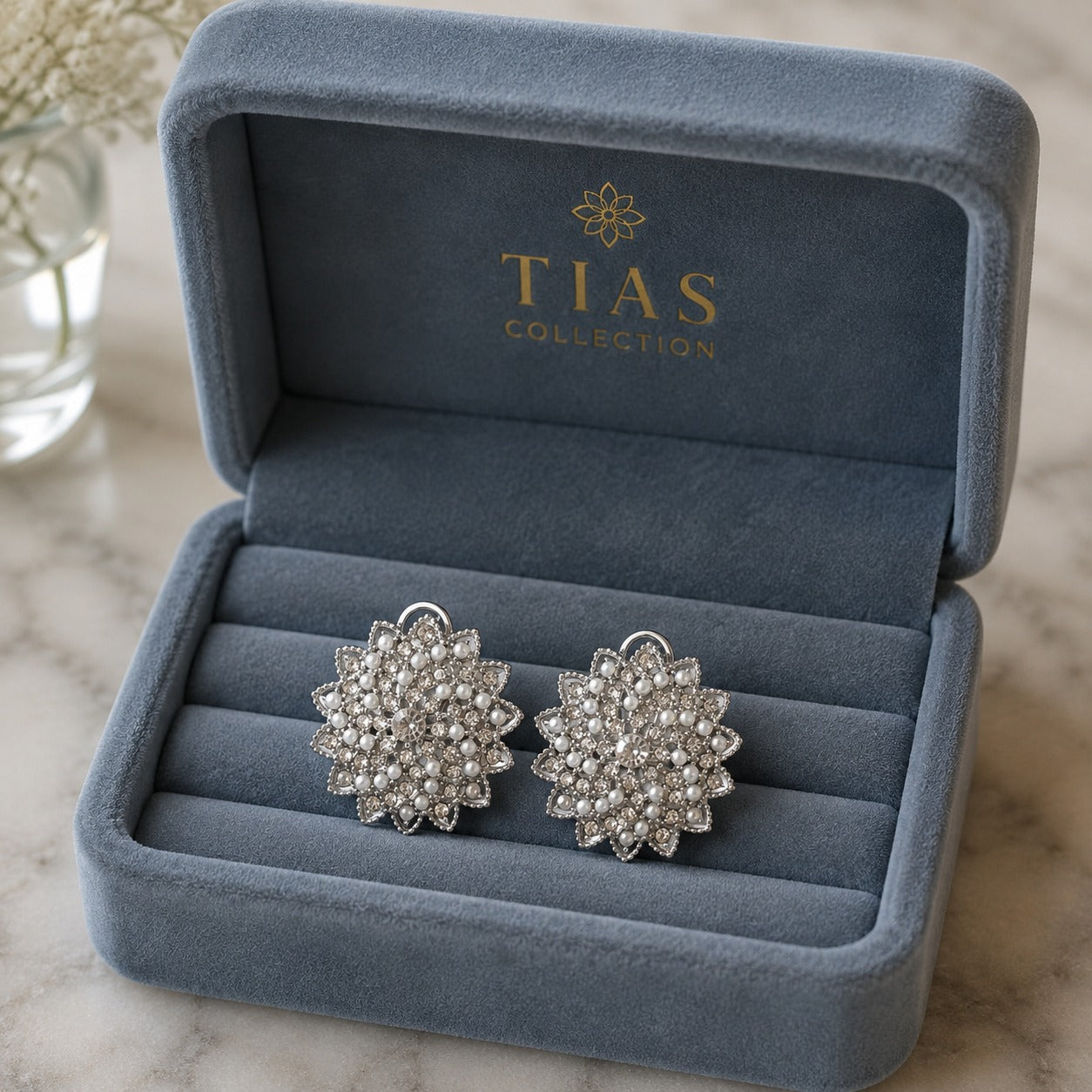 Silver-tone statement clip earrings featuring an intricate radial design embellished with miniature pearls and clear sparkling stone