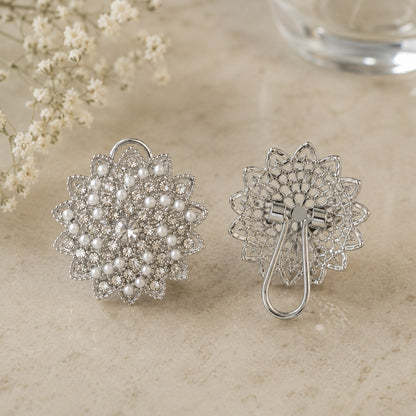 Back view of silver-tone pearl and crystal statement earrings showing the detailed openwork construction and clip-style fastening.