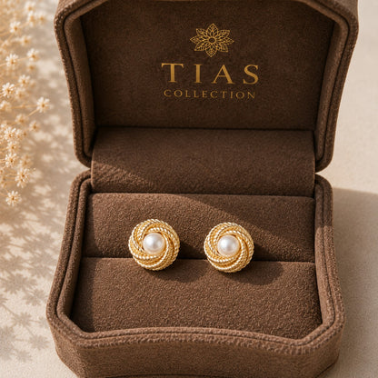 Gold-tone round stud earrings with a creamy pearl centre surrounded by layered rope-textured circular coils in a box