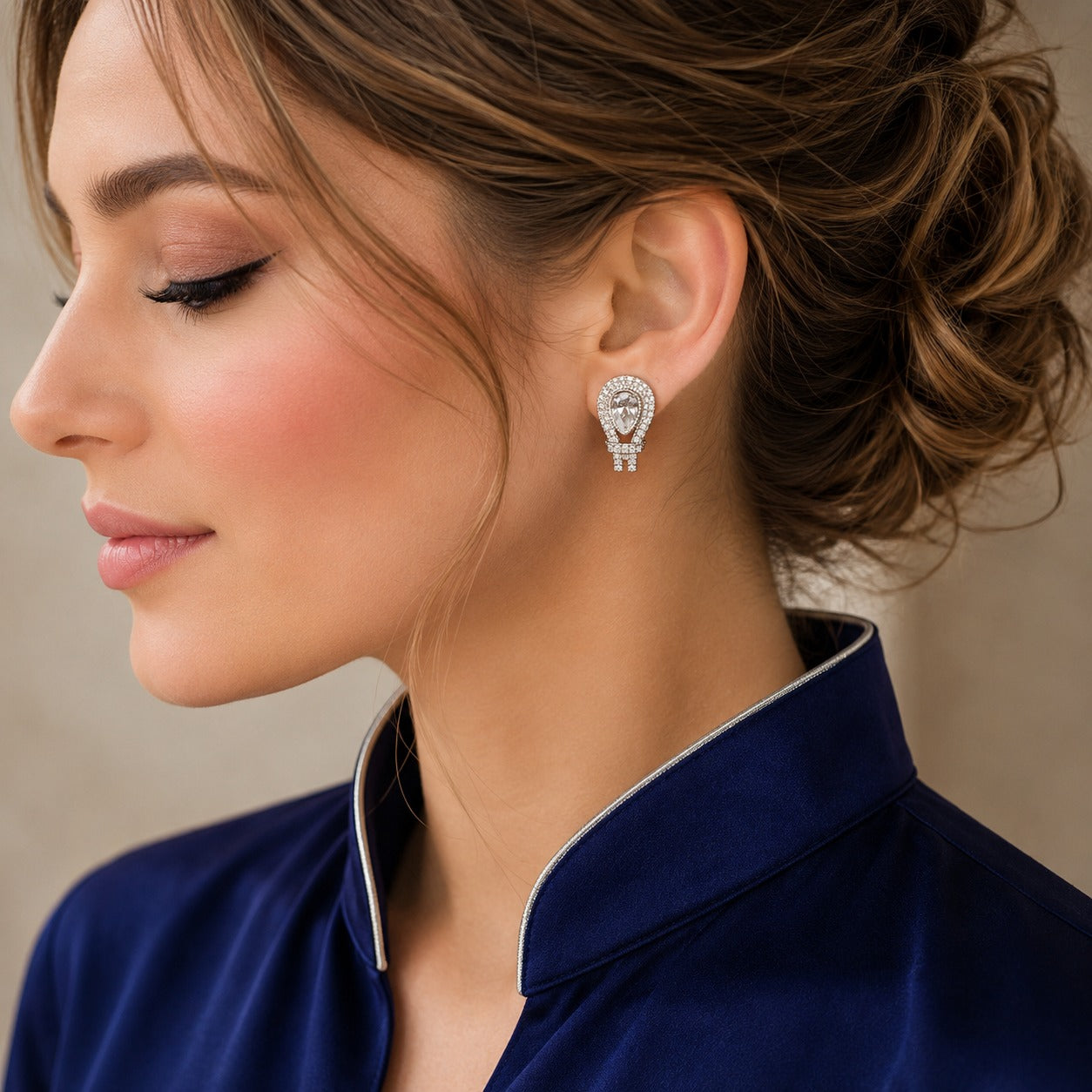 Model wearing silver-tone teardrop earrings featuring clear pear-cut zircon centres and sparkling pavé accents.