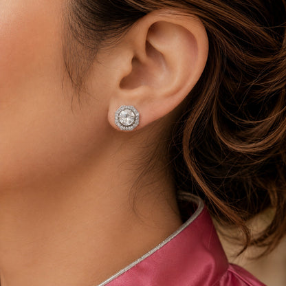 Silver-tone geometric stud earring with a large clear centre zircon and fine zircon border, shown worn on the ear.