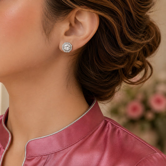 Silver-tone geometric stud earring with a large clear centre zircon and fine zircon border, shown worn on the ear.