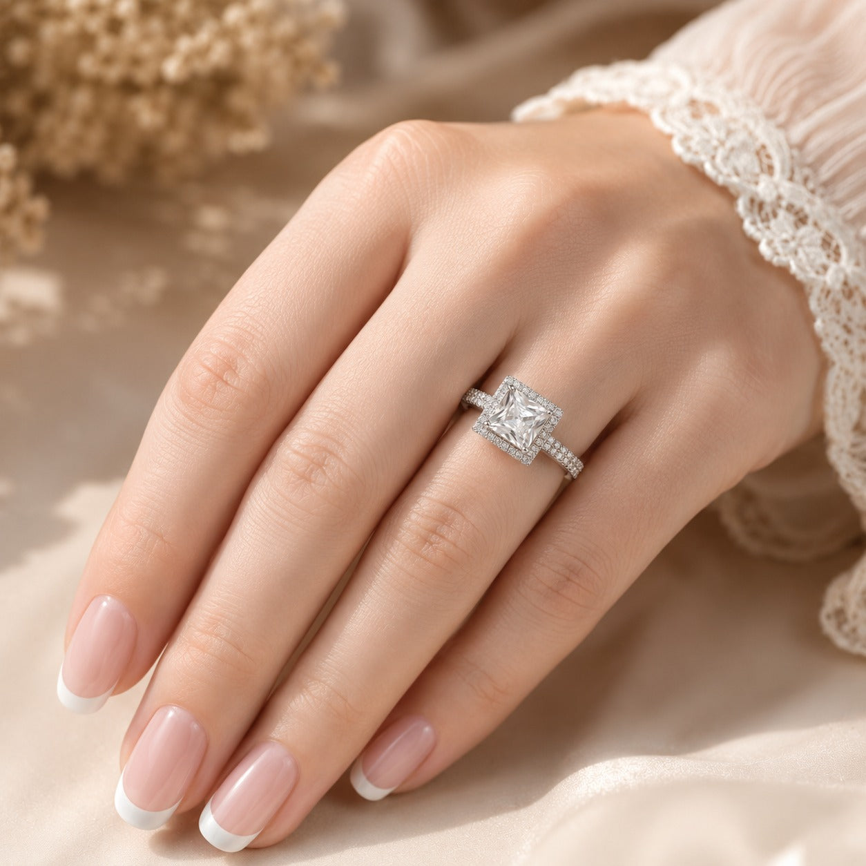  Crystal Clear Square-cut statement ring worn on a manicured hand, showcasing the faceted centre stone, sparkling halo and stone-set band