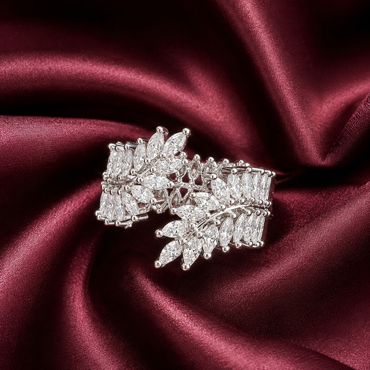 Front close-up of S925 silver statement band with overlapping marquise clear stones displayed on deep burgundy satin.