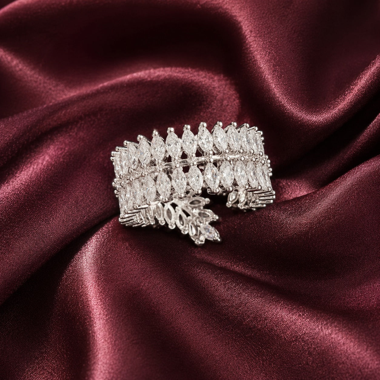 Back close-up of S925 silver statement band with overlapping marquise clear stones displayed on deep burgundy satin.
