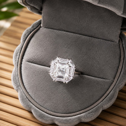 Cutglass Square S925 silver ring featuring a clear square centre stone and geometric baguette-cut surround displayed in a grey jewellery b