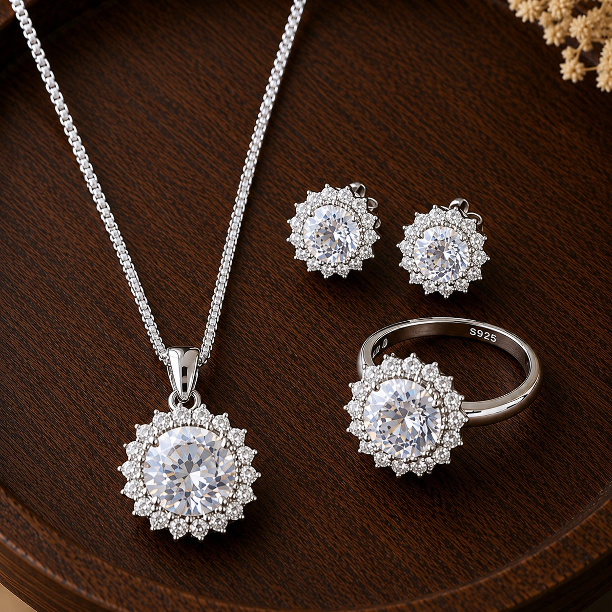S925 silver earrings, pendant necklace and matching ring set with round clear centre stones and detailed clear stone borders displayed on dark wood.