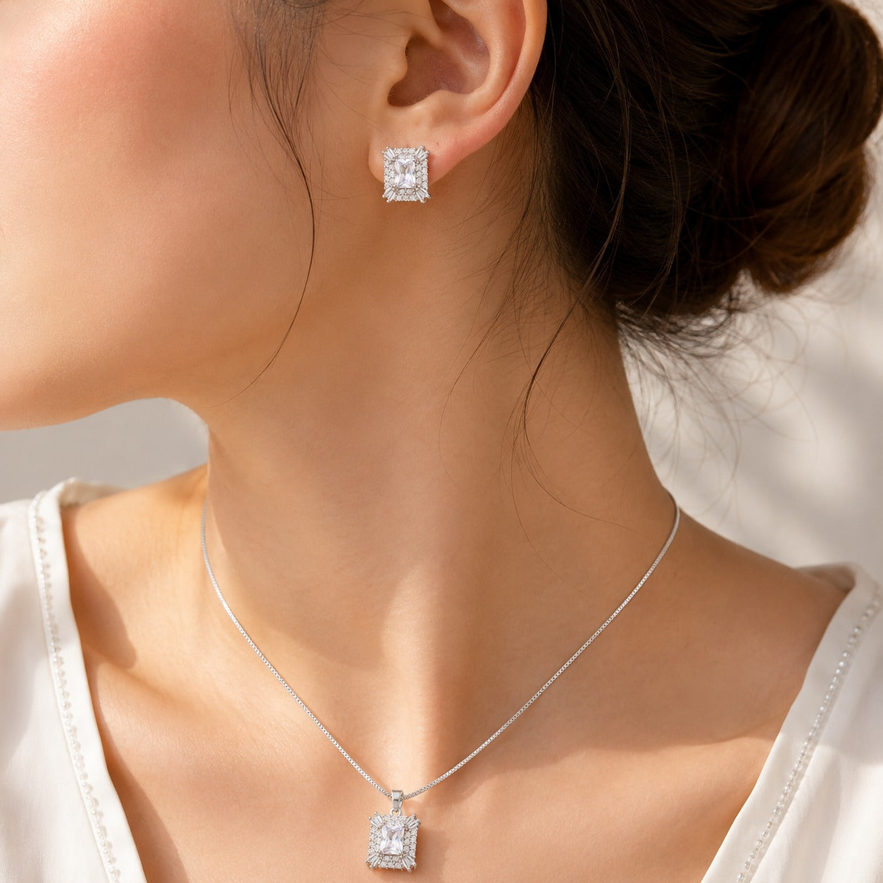 Model wearing the Veyra S925 silver pendant necklace with matching rectangular clear zircon earrings.