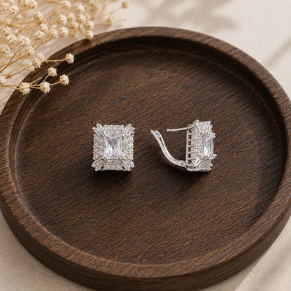 Close-up of Veyra S925 silver earrings featuring rectangular clear centre zircons with pavé and baguette zircon detailing.