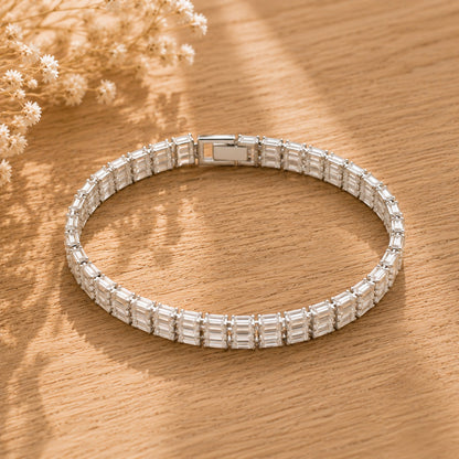 Silver-tone Prism Line Bracelet with rows of clear baguette-cut stones displayed on a warm wooden surface.