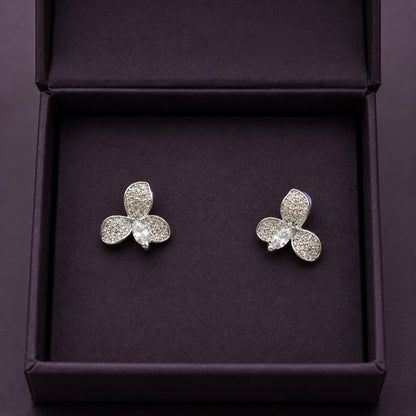 S925 Tria Glint Stud Earrings featuring three zircon-set petal forms with a marquise-cut clear zircon centre, displayed in a deep plum jewellery box.
