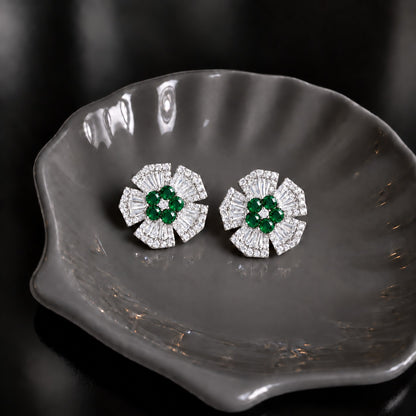 Radiant Crest Stud earrings with clear baguette zircon detailing and green centre stones, displayed on a smoky grey dish.