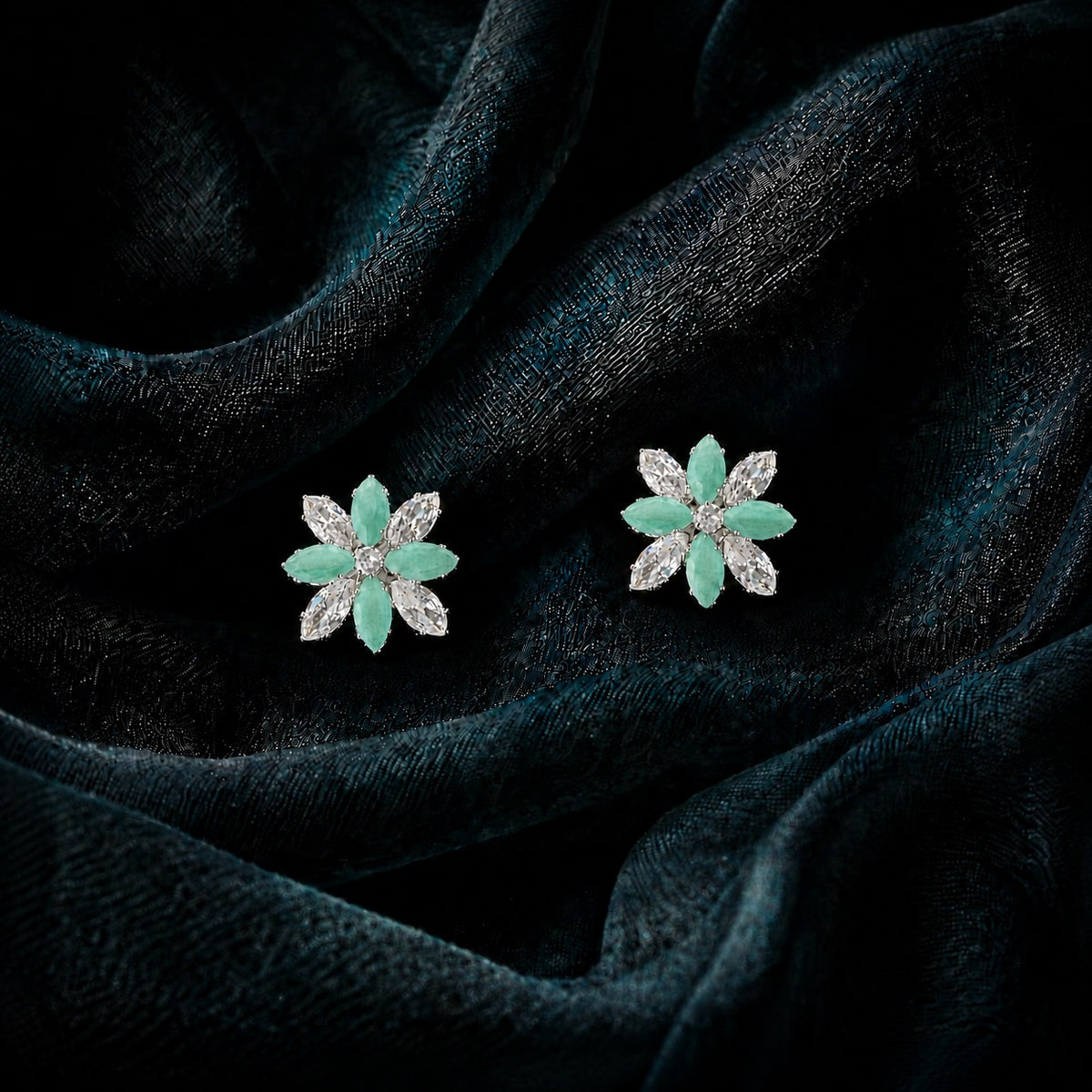 Close-up of Petal Circuit stud earrings featuring alternating coloured and clear marquise-cut stones arranged in an eight-petal floral design with a sparkling centre.