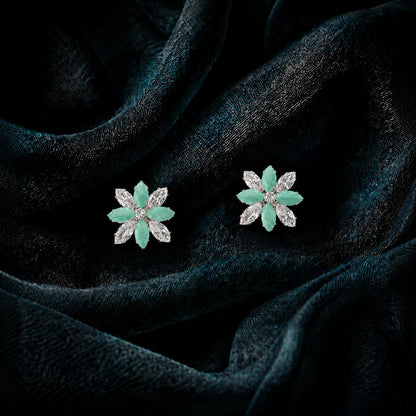 Close-up of Petal Circuit stud earrings featuring alternating coloured and clear marquise-cut stones arranged in an eight-petal floral design with a sparkling centre.