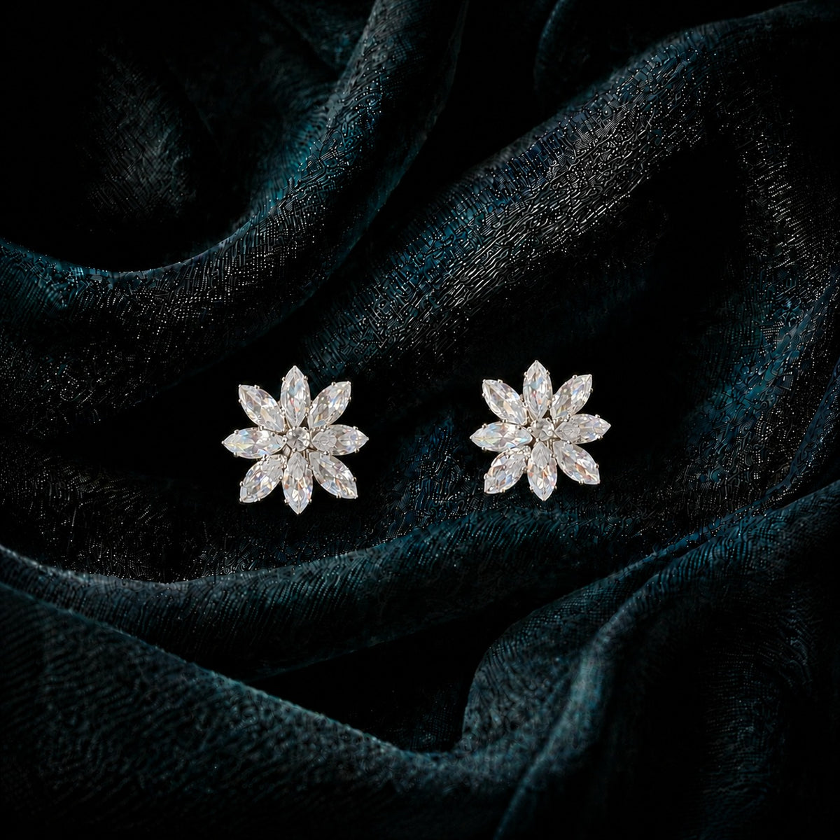 Close-up of Petal Circuit stud earrings featuring alternating coloured and clear marquise-cut stones arranged in an eight-petal floral design with a sparkling centre.