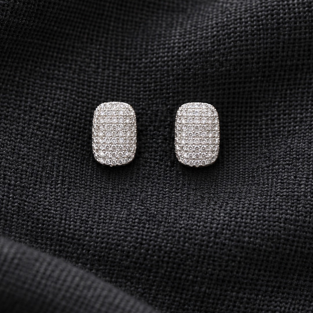 Pair of silver-tone geometric stud earrings featuring an all-over grid of tiny clear stones in a softly rounded rectangular shape.