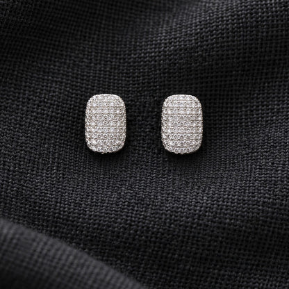 Pair of silver-tone geometric stud earrings featuring an all-over grid of tiny clear stones in a softly rounded rectangular shape.