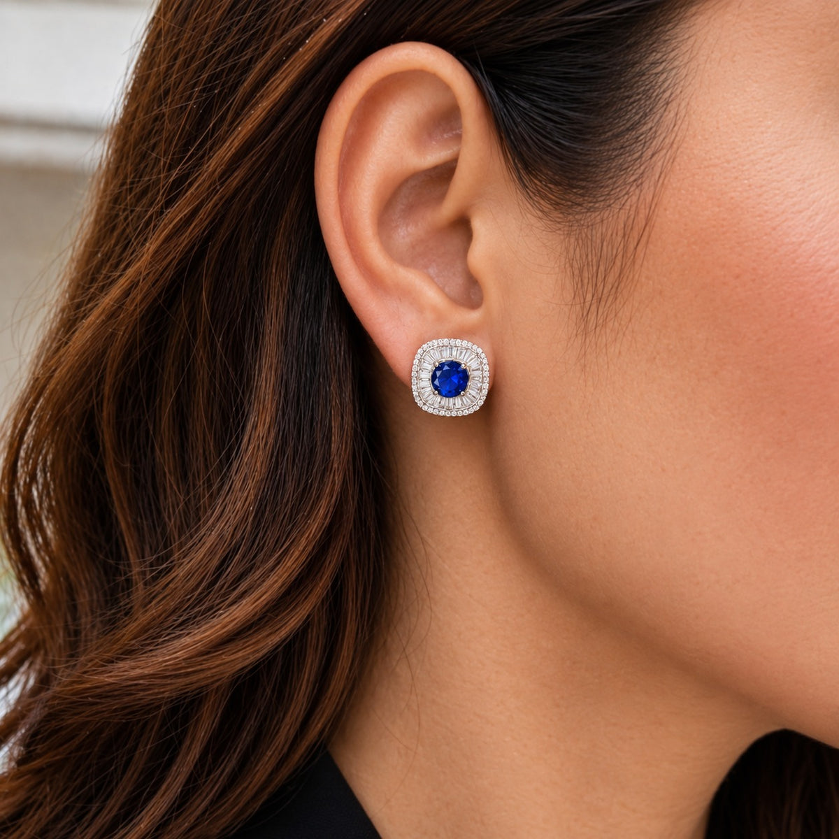 Model wearing Prism Court Stud with sapphire-blue centre stone and polished silver-tone zircon setting