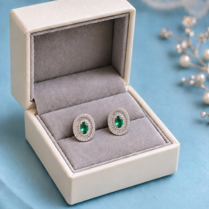 Crownline Oval Studs featuring a faceted oval green centre crystal framed by baguette-cut and round clear zircon stones in a polished silver-tone setting.