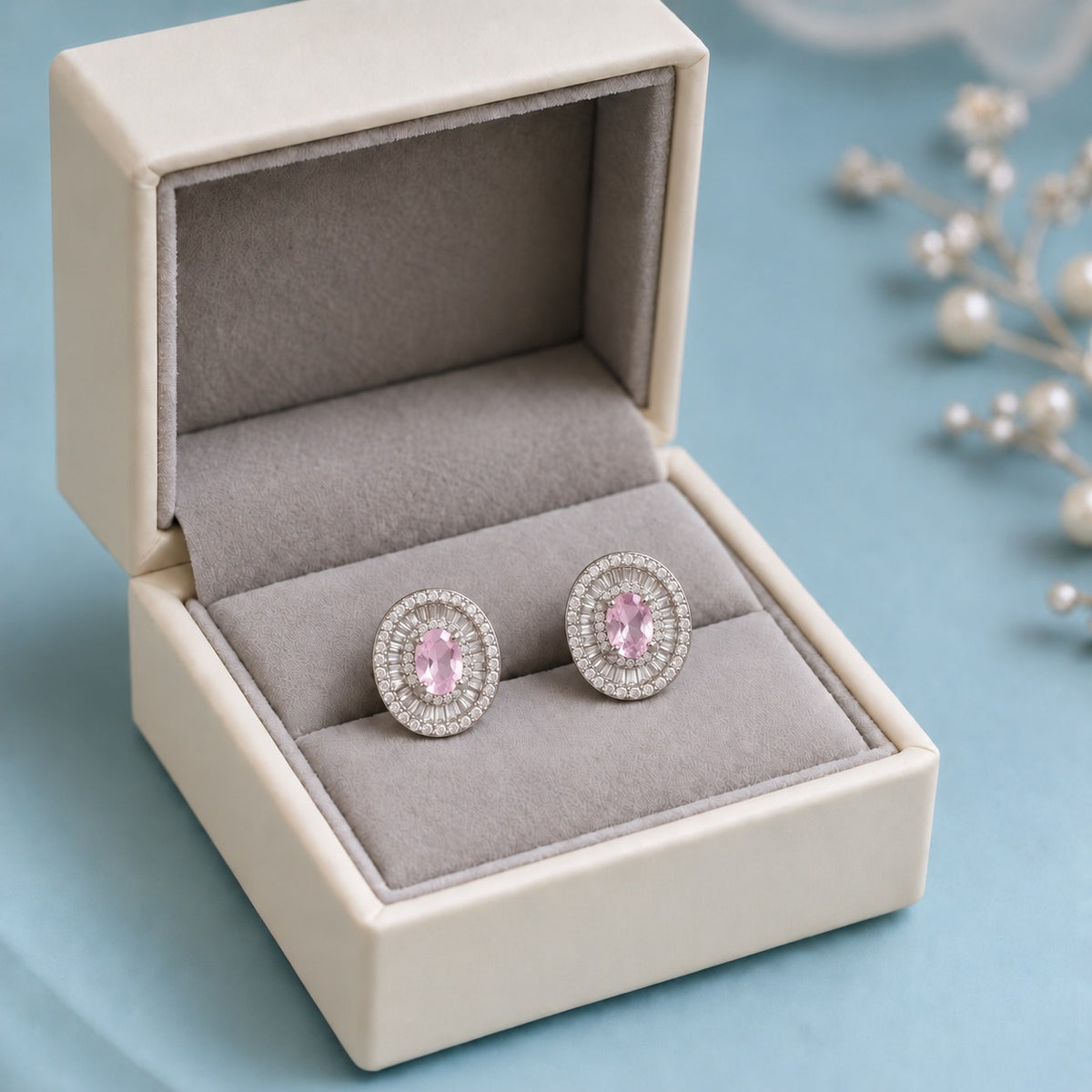 Crownline Oval Studs featuring a faceted oval soft pink centre crystal framed by baguette-cut and round clear zircon stones in a polished silver-tone setting.