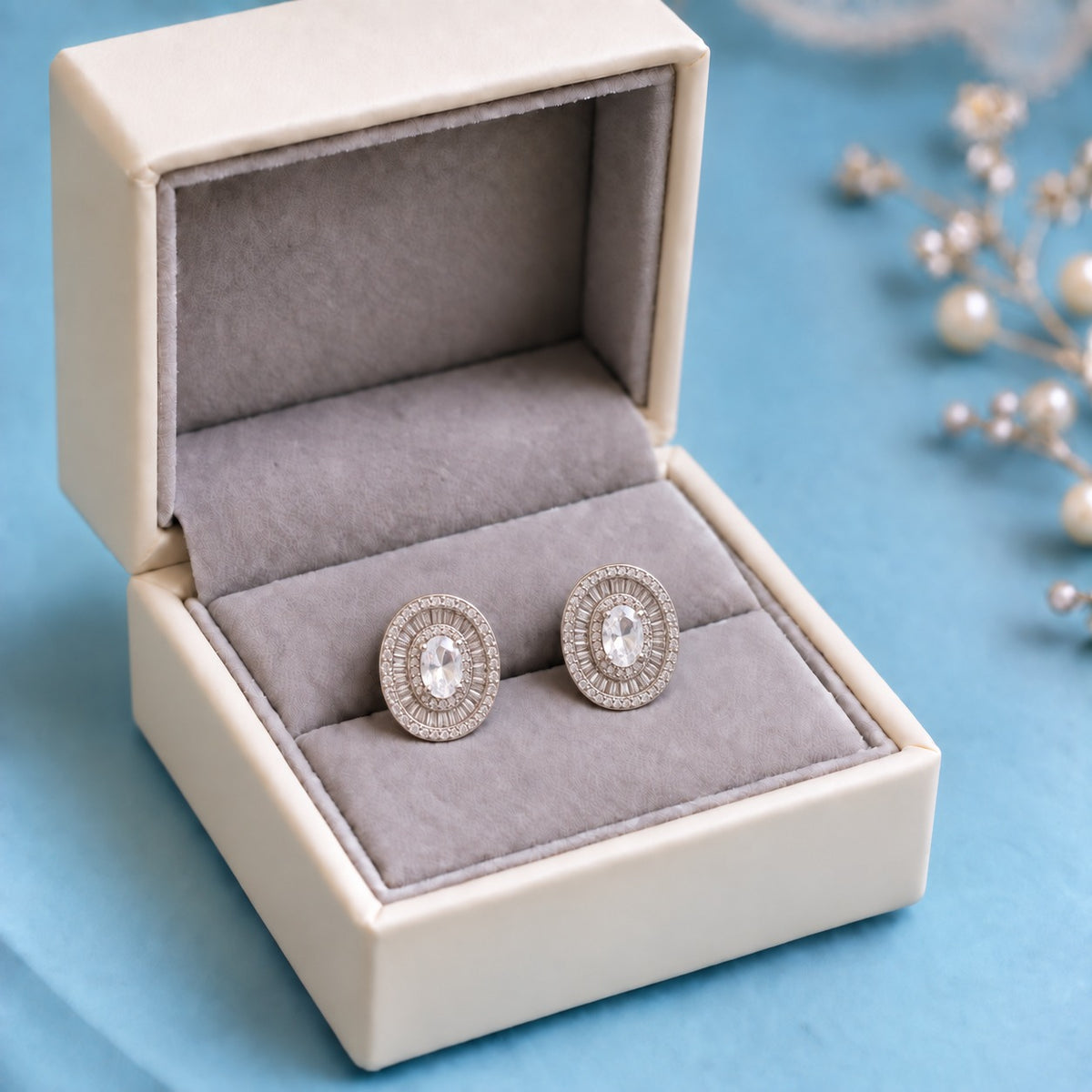 Crownline Oval Studs featuring a faceted oval clear centre crystal framed by baguette-cut and round clear zircon stones in a polished silver-tone setting.
