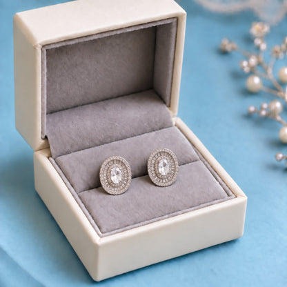 Crownline Oval Studs featuring a faceted oval clear centre crystal framed by baguette-cut and round clear zircon stones in a polished silver-tone setting.